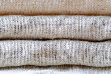 Neatly folded woven linen fabric in neutral shade
