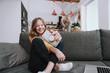 © Yakobchuk Olena - Cheerful little girl sitting on couch and making selfie