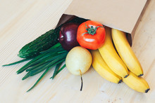 Paper Bag With Fresh Vegetables And Fruits On A Wooden Table.
