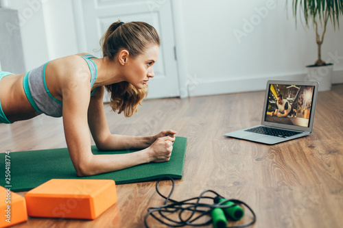 Fotomural Young lady doing plank practice at home
