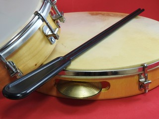 Close-up of two Brazilian percussion musical instruments: pandeiro (tambourine) and tamborim with drumstick. The instruments are widely used to accompany samba, a popular Brazilian rhythm. 