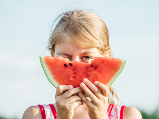 Portrait of blonde little girl with watermelon