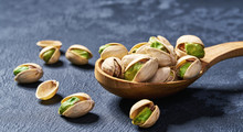 Pistachios  In Wooden Spoon  On Black Table,close-up