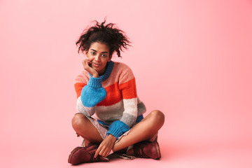 Wall Mural - Happy beautiful young african woman posing isolated over pink wall background.