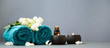 Leinwandbild Motiv Spa still life with candles, towels and flowers on grey background copy space