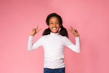 Happy Preteen Girl Showing Peace Sign, Pink Background