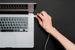 © Mihail - persons hand insert usb wire in a laptop isolated b