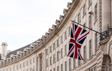 british flag on the background of the historic building of london, uk
