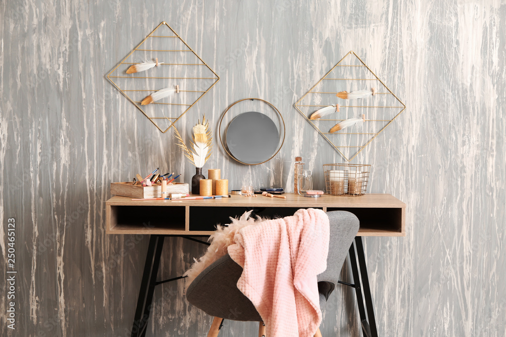 Dressing table with set of cosmetics near grunge wall