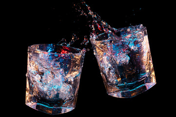 Splashes from toasting rocks glasses on a black background