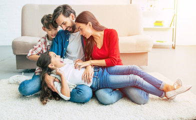 Wall Mural - Young happy family relax together at home smiling and hugging