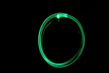 Wall Mural - Long exposure, light painting photography.  Abstract circle outline design, vibrant green color against a black background