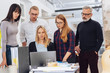© contrastwerkstatt - Team gathered around one desk at computer