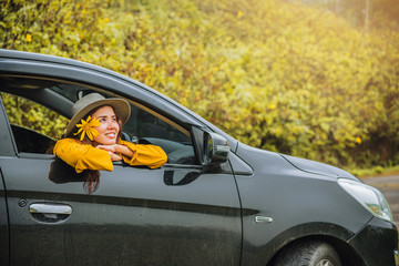 Asian women are on vacation. Drive happily traveling to the Mexican sunflower flower garden in Thailand.