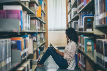 Beautiful asian woman wear glasses looking  a book in the library