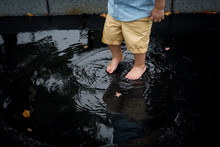 Barefoot Toddler Steps In Puddle