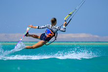 Kite Surfing Girl In Sexy Swimsuit With Kite In Sky On Board In Blue Sea Riding Waves With Water Splash. Recreational Activity, Water Sports, Action, Hobby And Fun In Summer Time. Kiteboarding Sport