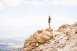 © Cavan Images - Side view of woman looking at landscape while standing on rocks against cloudy sky
