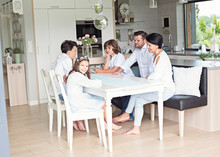  Family Eating Meal Around Kitchen Table Together 
