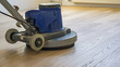 Renovieren von Parkett mit Einscheibenmaschine, polieren, Reinigen oder schleifen von Fußboden.