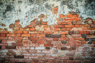 Grungy historical broken brick wall background in sunny summer day. Abstract red brick old wall texture background. Ruins uneven crumbling red brick wall background texture.