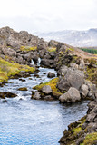 Fototapeta Łazienka - Thingvellir National Park with autumn foliage in Iceland Golden circle and vertical view of small waterfall on rocky trail with blue water landscape