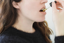 Woman Ingesting Oil Under Tongue