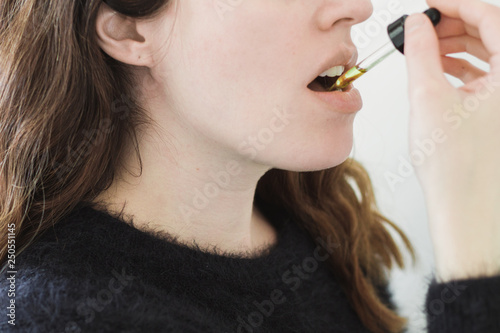 Woman Ingesting Oil Under Tongue