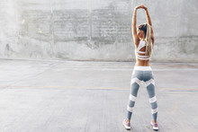 Fitness Sport Woman In Fashion Sportswear Doing Stretching Exercise Over Gray Wall