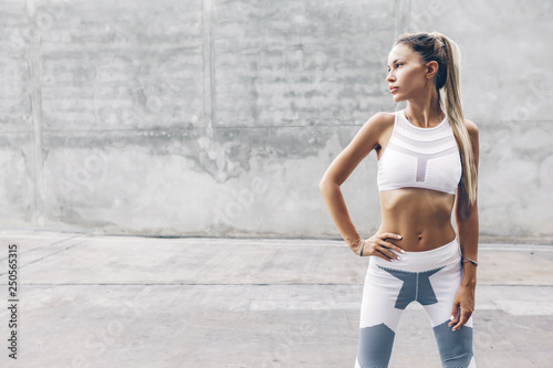 Fotografía Fitness sport model in fashion sportswear posing over gray wall