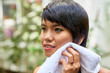 © DragonImages - Sportswoman wiping face with towel