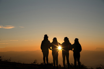 Group of friends standing together on greensward and enjoying themselves. Young women enjoying on their holiday outdoors.