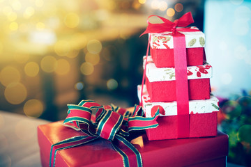 Stacked of gift boxes on table with blurred light background. Holiday and celebration concept.