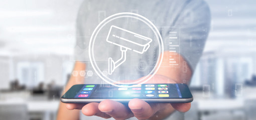 Poster - Businessman holding Security camera system icon and statistics data - 3d rendering