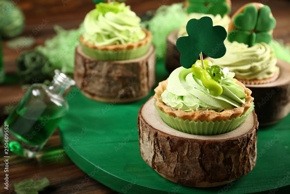 Tasty cakes with clover on board, closeup. St. Patrick's Day celebration