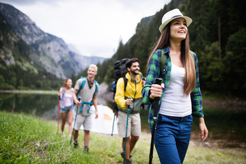 Sticker - Group of smiling friends hiking with backpacks outdoors. Travel, tourism, hike and people concept.