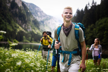 group of happy friends with backpacks hiking together