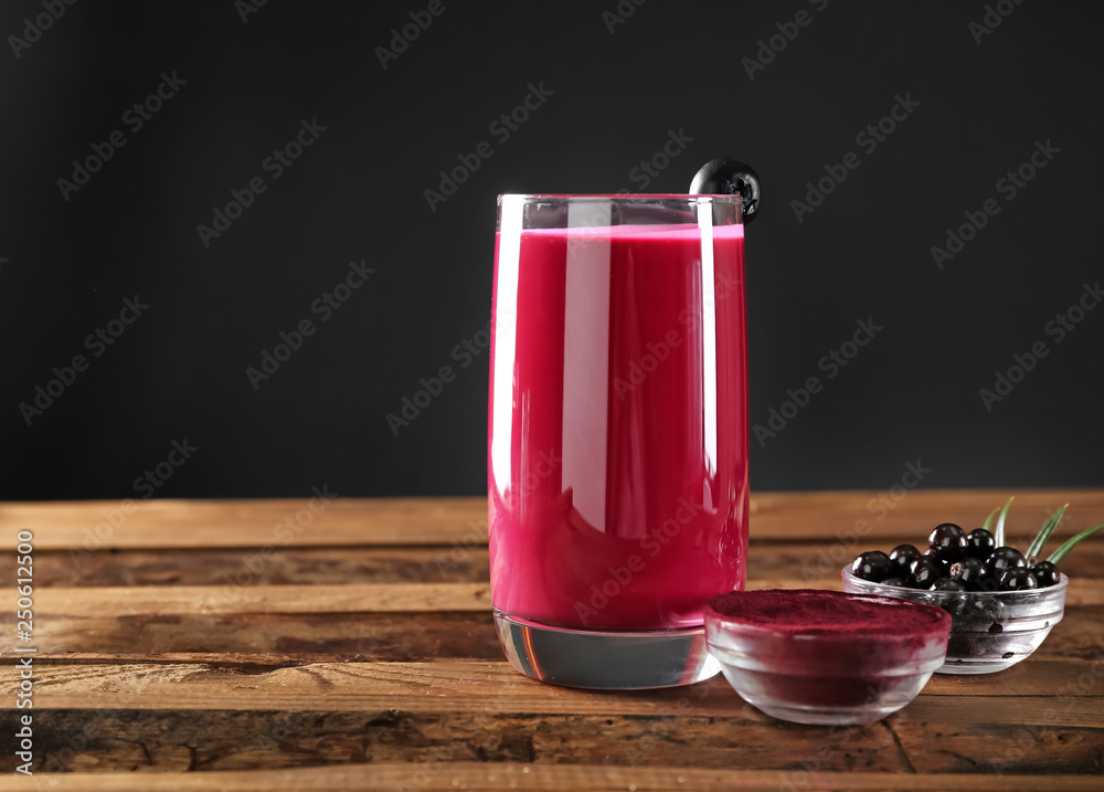 Glass of acai smoothie on wooden table