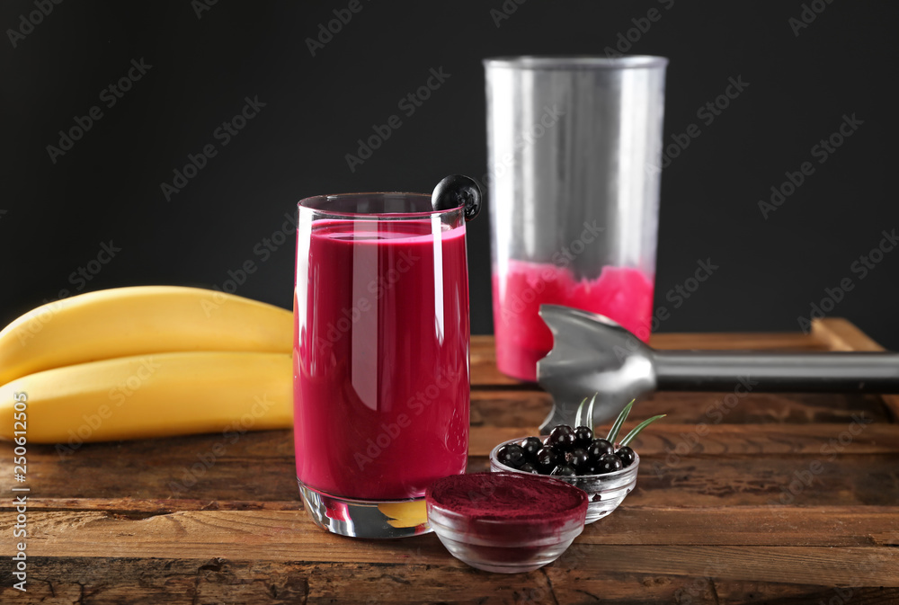 Glass of acai smoothie on wooden table