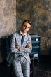 © olegzaicev - A man in a blue suit is sitting on a chair