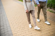 © LIGHTFIELD STUDIOS - cropped view of senior couple walking across paved sidewalk in park