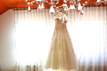 beautiful white wedding dress hanging up in a window