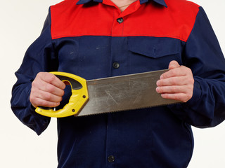 Wall Mural - man in workwear is holding a handsaw tool on white background.