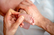 © Sergey - Photo from above of kid’s feet and hands of masseur.