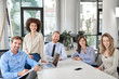 © nenadaksic - Small group of business people posing in office. Start up business concept. Multi ethnic group.