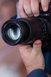 © biggur - Male hands holding a digital SLR camera close up