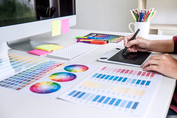 Poster - Image of female creative graphic designer working on color selection and drawing on graphics tablet at workplace