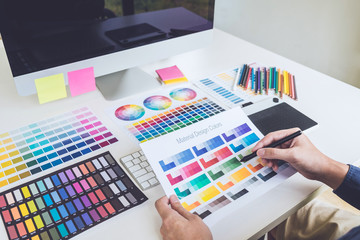 Poster - Image of male creative graphic designer working on color selection and drawing on graphics tablet at workplace with work tools and accessories