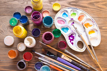 Multicolored plastic cans with paints. Artist workplace background. Old dirty Paints background. Colorful artist palette. Creativity, visual art concept. Art and craft.