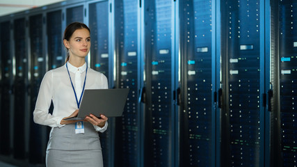 Aufkleber - Beautiful Data Center Female IT Technician Walking Through Server Rack Corridor with a Laptop Computer. She is Visually Inspecting Working Server Cabinets.